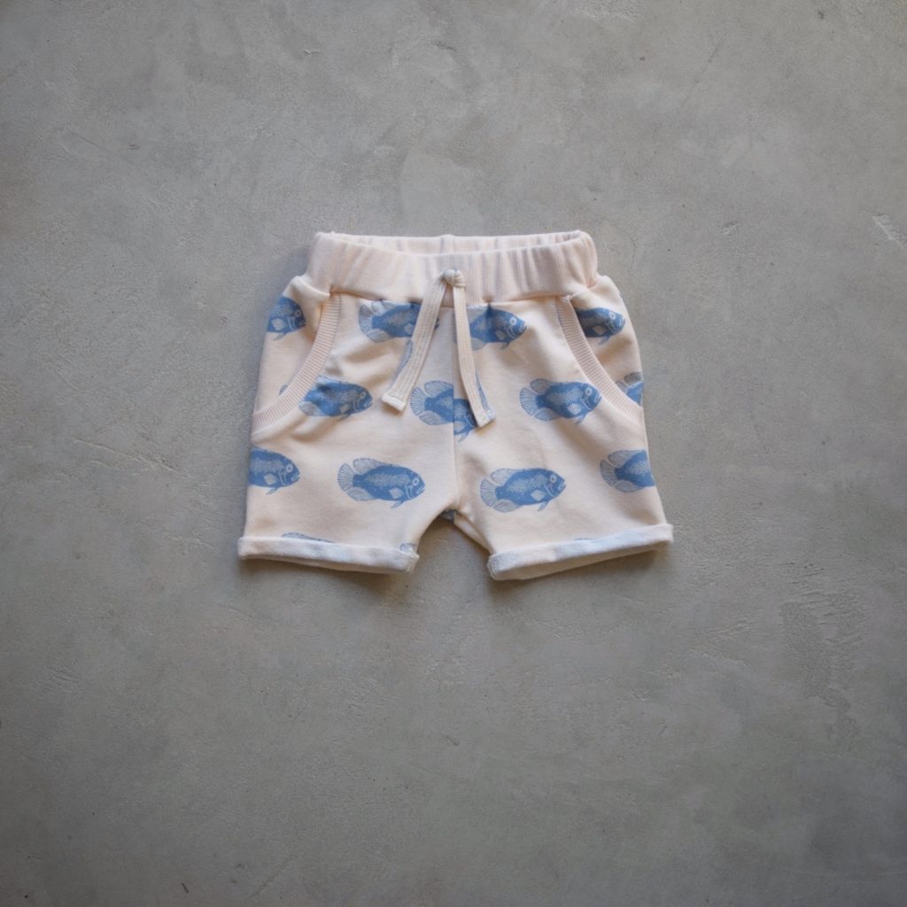 Short pour petit garçons en sweat léger, à motifs poissons bleu sur fond crème.